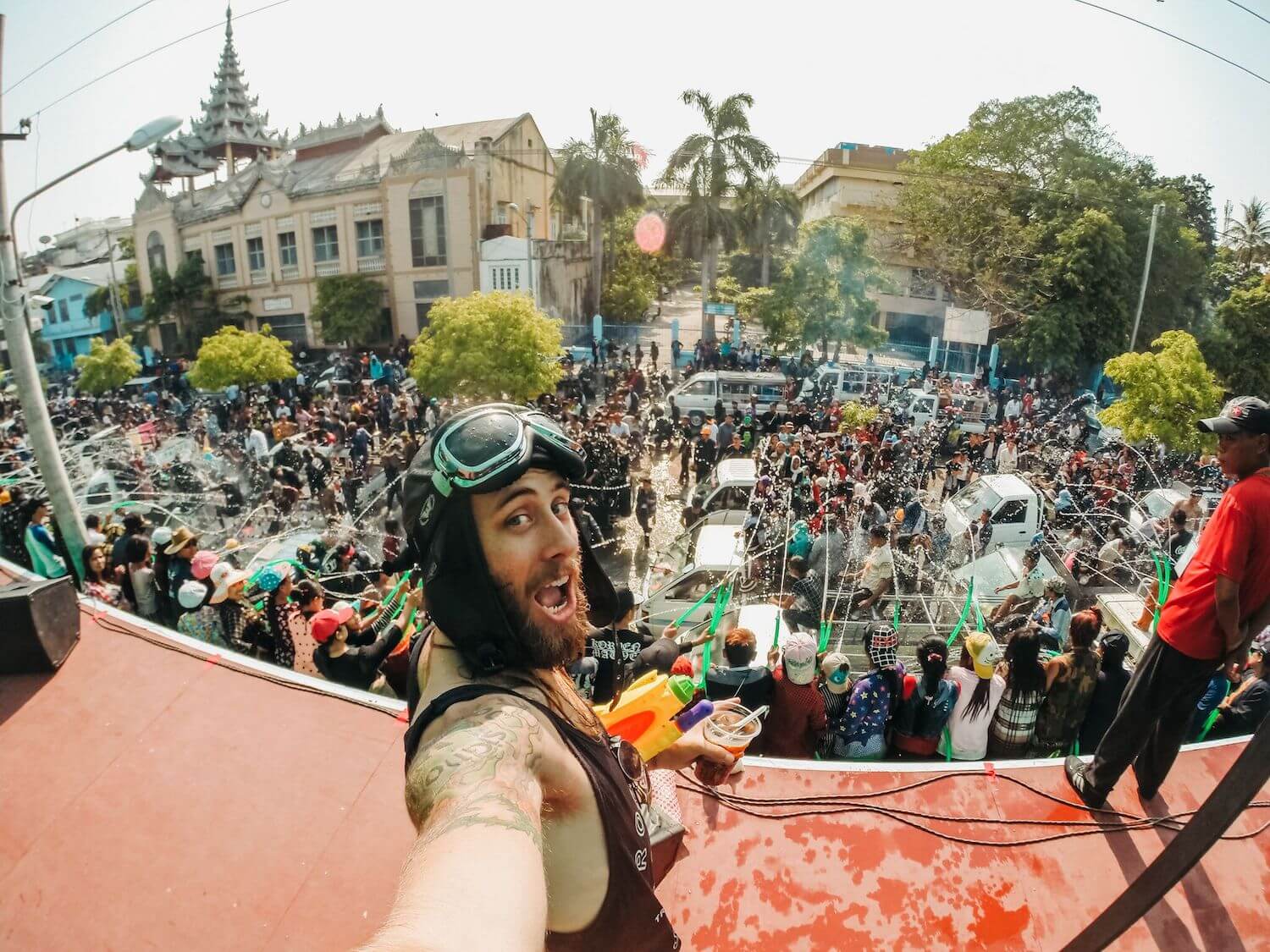 Best Myanmar Itinerary: Photo of crowds of Myanmar people in Mandalay partying and having a water battle during Thingyan Festival, with Ryan on stage dancing. Photo by Ryan Brown of Lost Boy Memoirs, edited in Lightroom.